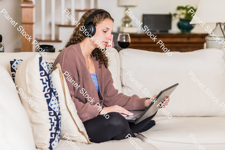 A young lady sitting on the couch stock photo with image ID: 65d03fb0-3b0d-4018-8057-cc0a058c239b