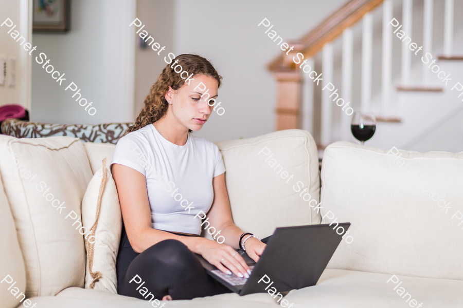 A young lady sitting on the couch stock photo with image ID: 676c1c80-a0f7-444c-8390-6b17f0ed608a