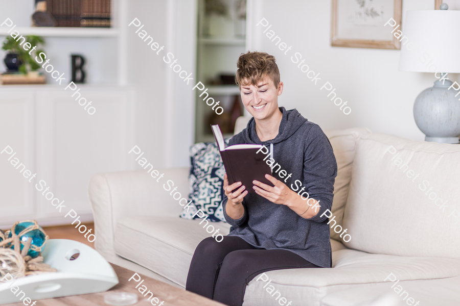 A young lady sitting on the couch stock photo with image ID: 67a745e8-a450-43f1-917f-c99692d86905
