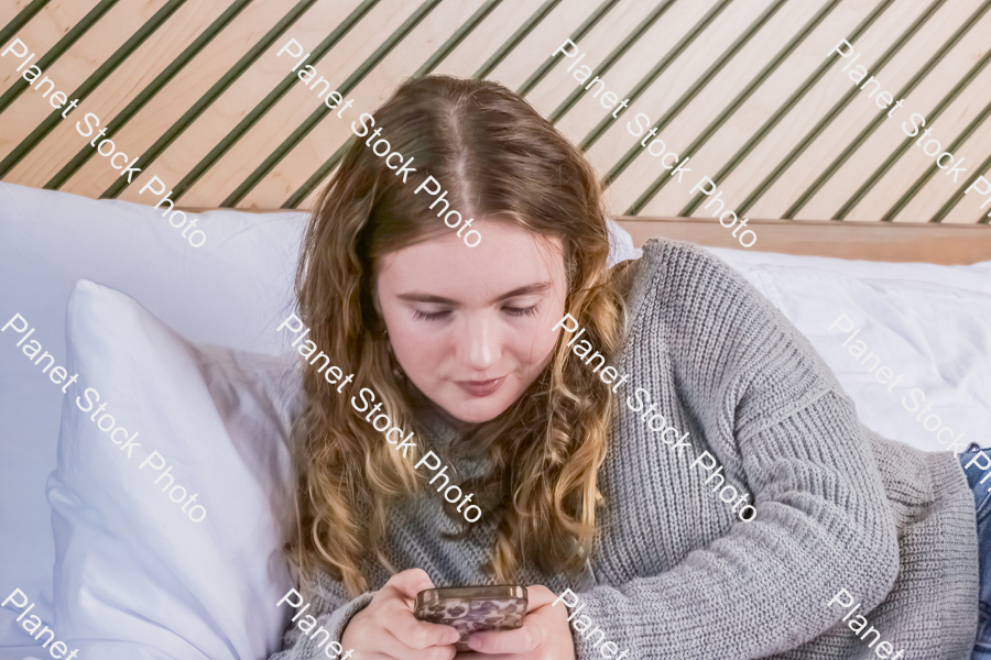 A girl in bed, using a mobile phone stock photo with image ID: 6a2936e5-d47b-490b-a5f5-5e7a59e83a2e