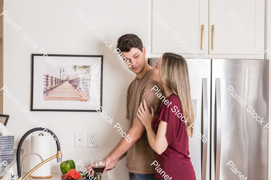 A young couple preparing a meal in the  kitchen stock photo with image ID: 6ba1a36f-8880-499f-ac77-49a471422296