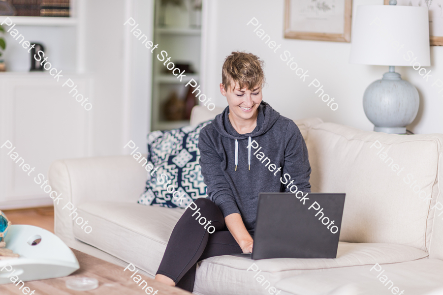 A young lady sitting on the couch stock photo with image ID: 6defe818-d252-448d-8ecc-8b056fbd2e7c