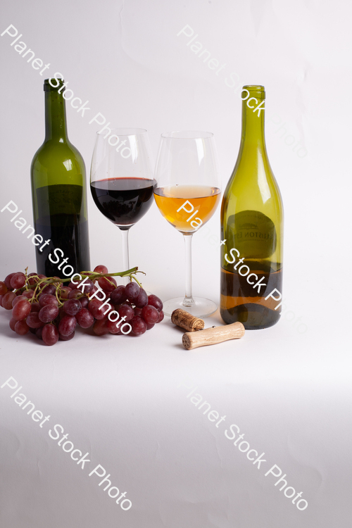 Two bottles of wine, with corkscrew, grapes, and wine glasses stock photo with image ID: 6e877a70-a24b-4d47-9d95-3f23a7388391