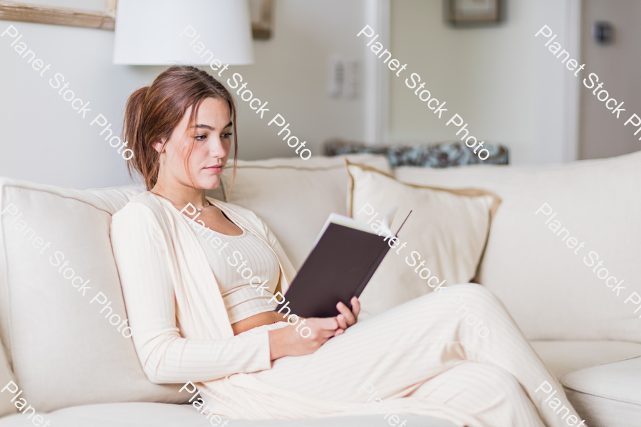 A young lady sitting on the couch stock photo with image ID: 72081e0f-79ad-4e38-923a-dd5e48f78cec