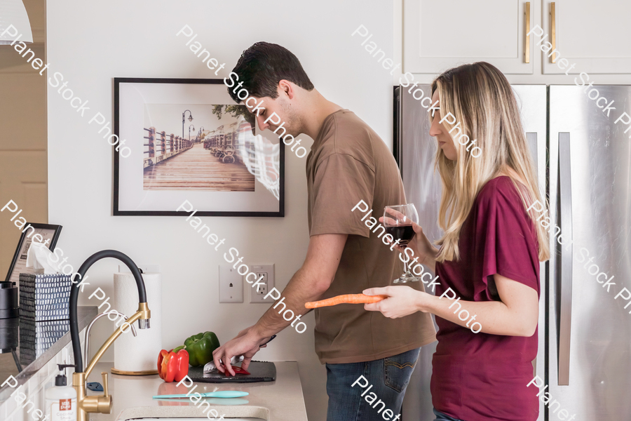 A young couple preparing a meal in the  kitchen stock photo with image ID: 7228cb68-2655-4f51-9757-a6f52156dc7d
