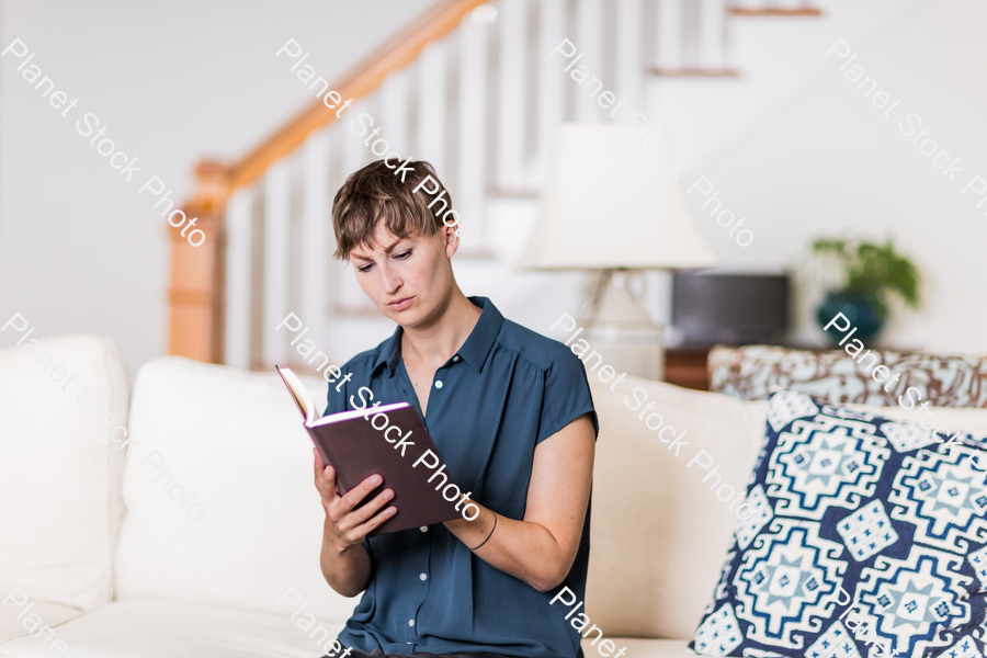 A young lady sitting on the couch stock photo with image ID: 73b4e30d-a2ab-486f-a4ea-b808d130bb46