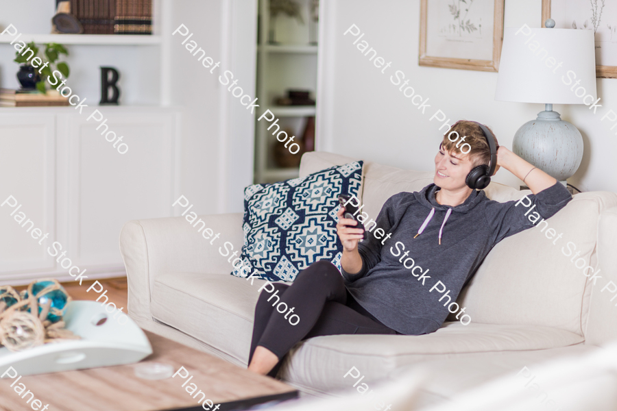 A young lady sitting on the couch stock photo with image ID: 74fd83cb-d3e0-4506-992a-d84a1351aed4