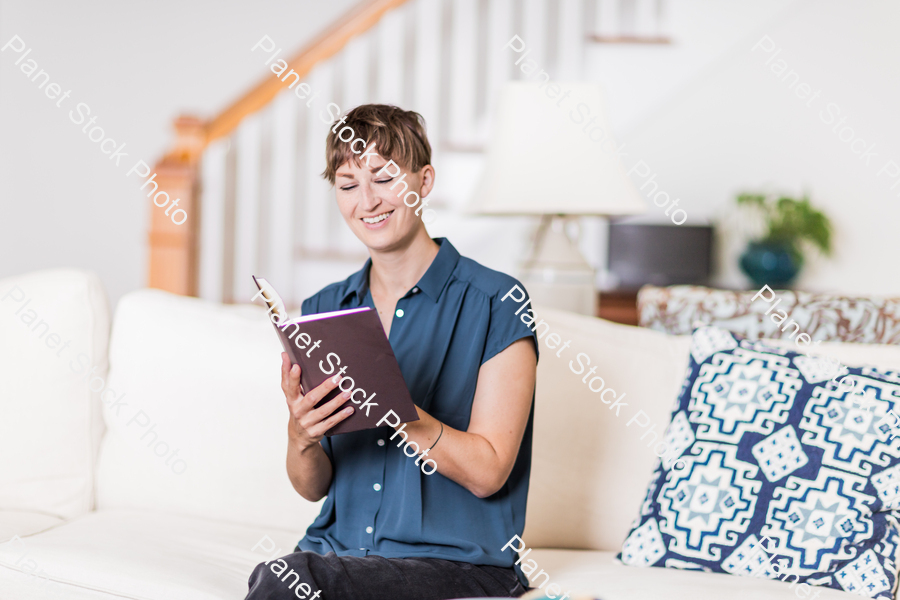 A young lady sitting on the couch stock photo with image ID: 764e4485-927e-4803-947e-543d74d5eb5a