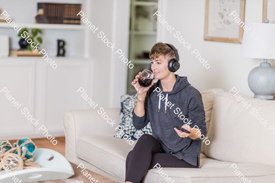 A young lady sitting on the couch stock photo with image ID: 778e0a82-d458-4d63-83b6-03bc6a8704bd