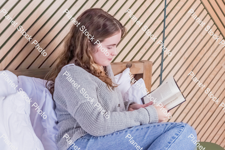 A girl reading a book in bed stock photo with image ID: 77e8bfee-c5bf-41a8-8dd7-f9307b70a934
