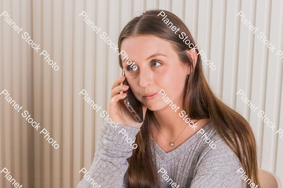 A girl sitting and using a mobile phone stock photo with image ID: 784fd2bc-8316-4401-8f82-a9ca73e1e4f9