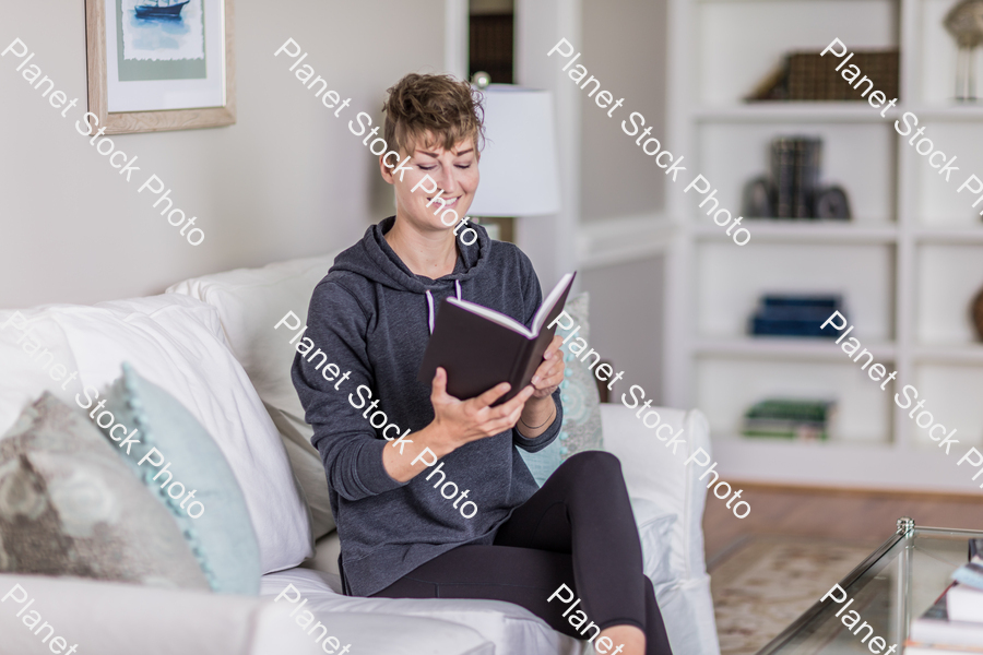 A young lady sitting on the couch stock photo with image ID: 792449bd-92ec-4826-94b8-35314e0ef9c5