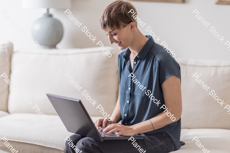 A young lady sitting on the couch stock photo with image ID: 7992aabf-460d-4453-8a1c-ee067656c163