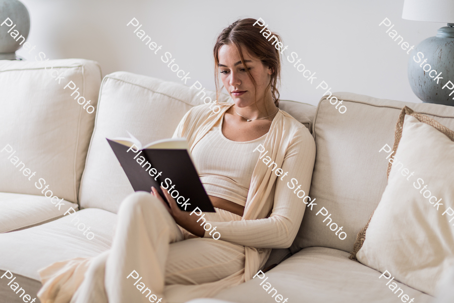 A young lady sitting on the couch stock photo with image ID: 7d51a7cb-f7c4-42b3-a0c5-a81a3e5062dd