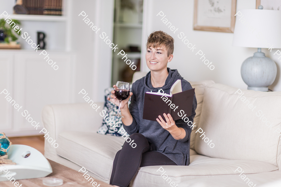 A young lady sitting on the couch stock photo with image ID: 7d9b891b-fd66-49b0-9bd1-d6eecec07d07