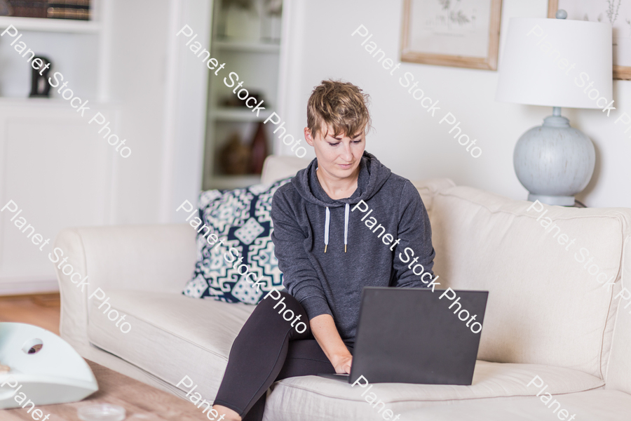 A young lady sitting on the couch stock photo with image ID: 7e0af2e6-8d0d-498a-87cc-5b9772c1deb7