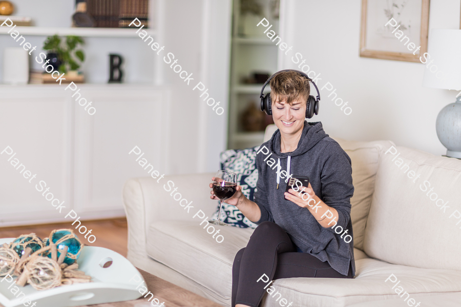 A young lady sitting on the couch stock photo with image ID: 815d2c7b-170f-4b24-b225-52ab829fef7a