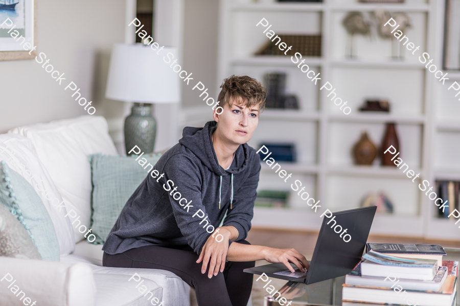 A young lady sitting on the couch stock photo with image ID: 81a46b19-1200-4302-80e4-e116ab2aab96