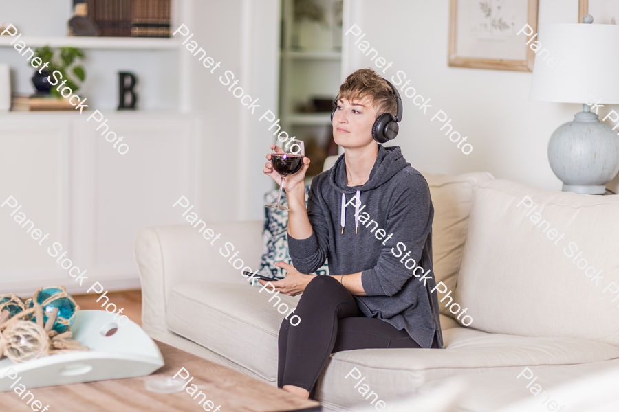 A young lady sitting on the couch stock photo with image ID: 821e7023-33ab-4082-ad52-1f270b615147