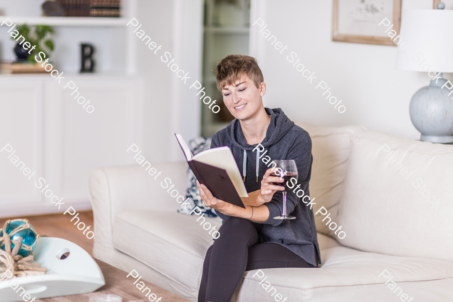 A young lady sitting on the couch stock photo with image ID: 835441d5-e9d4-4016-8c45-25978dfb574e