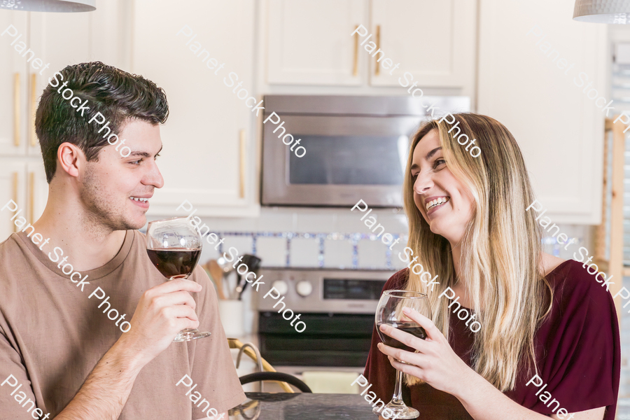 A young couple sitting and enjoying red wine stock photo with image ID: 84bb01fe-8589-481f-be15-59ff59e65211