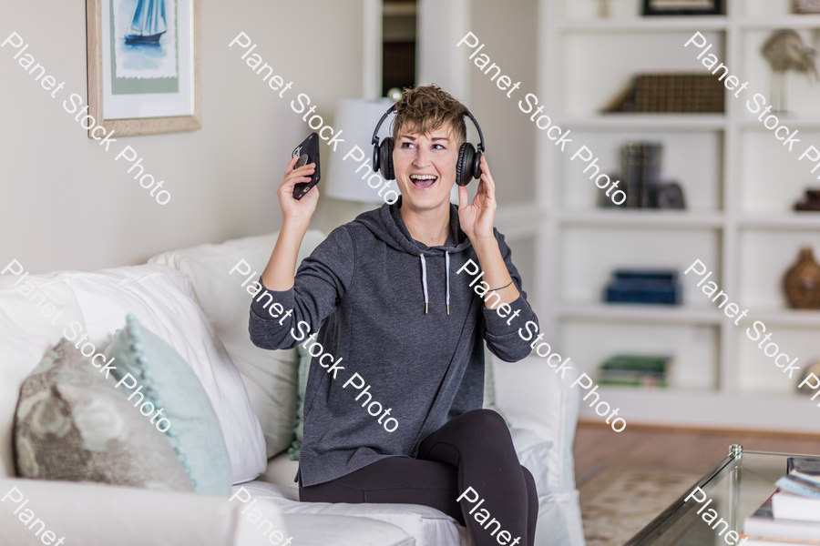 A young lady sitting on the couch stock photo with image ID: 87217525-14a9-45b4-8522-793ea2e6fb44