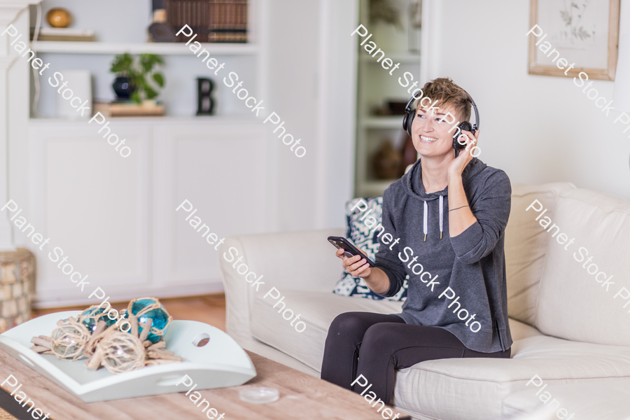 A young lady sitting on the couch stock photo with image ID: 87245f71-3c4b-4efa-a607-9a42f9afda5d