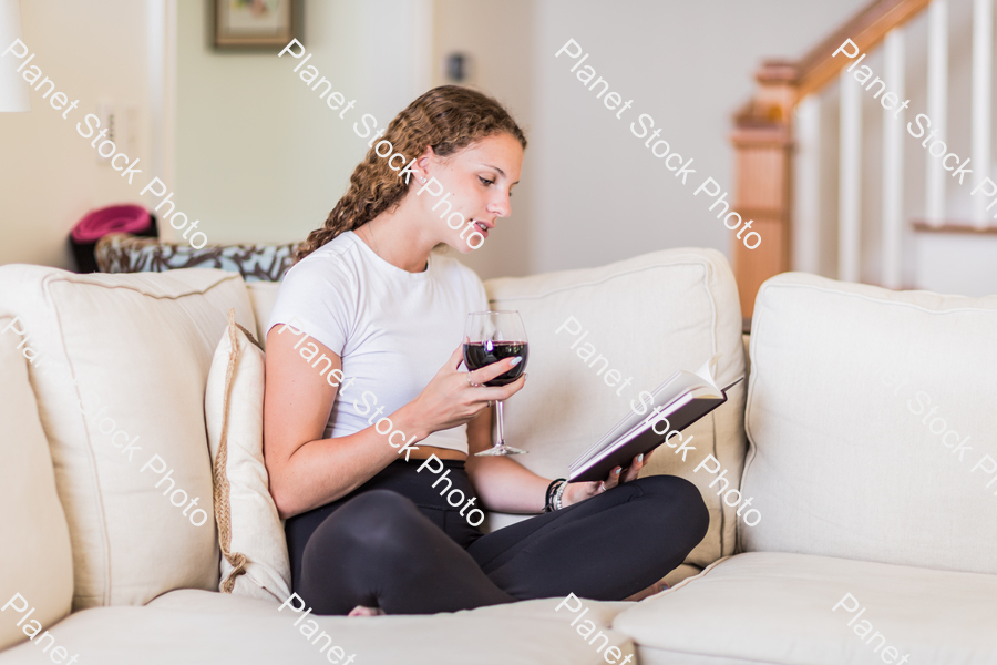 A young lady sitting on the couch stock photo with image ID: 87592133-c201-4ae9-be8f-bcf7e899c93a