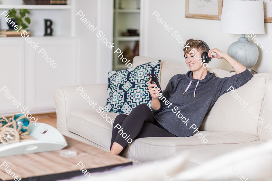 A young lady sitting on the couch stock photo with image ID: 890f46e0-1ab4-4ce7-a3e2-1df29cce2d09