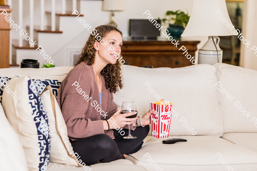 A young lady sitting on the couch stock photo with image ID: 89415c3d-b229-4c17-8506-5d0cdb563d59