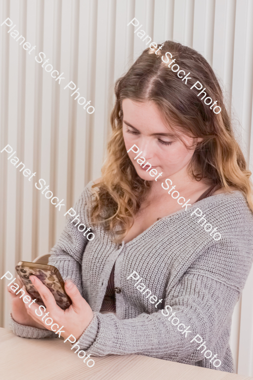 A girl sitting and using a mobile phone stock photo with image ID: 8bd3d9e1-555b-4692-9038-2267834230f0