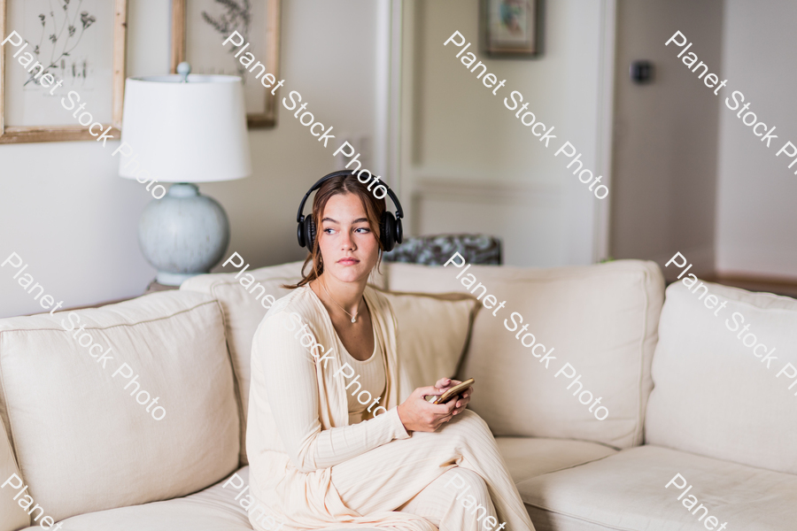A young lady sitting on the couch stock photo with image ID: 8de3d7f2-8dc4-45a2-adb3-373eedf8415a