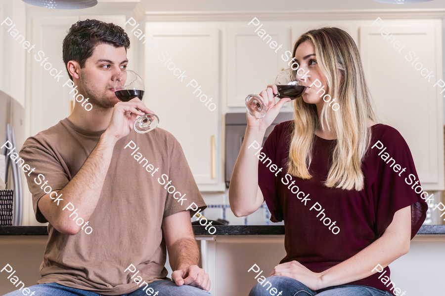 A young couple sitting and enjoying red wine stock photo with image ID: 8df6a0a9-6071-4caf-bf09-6d9c4be69ee9