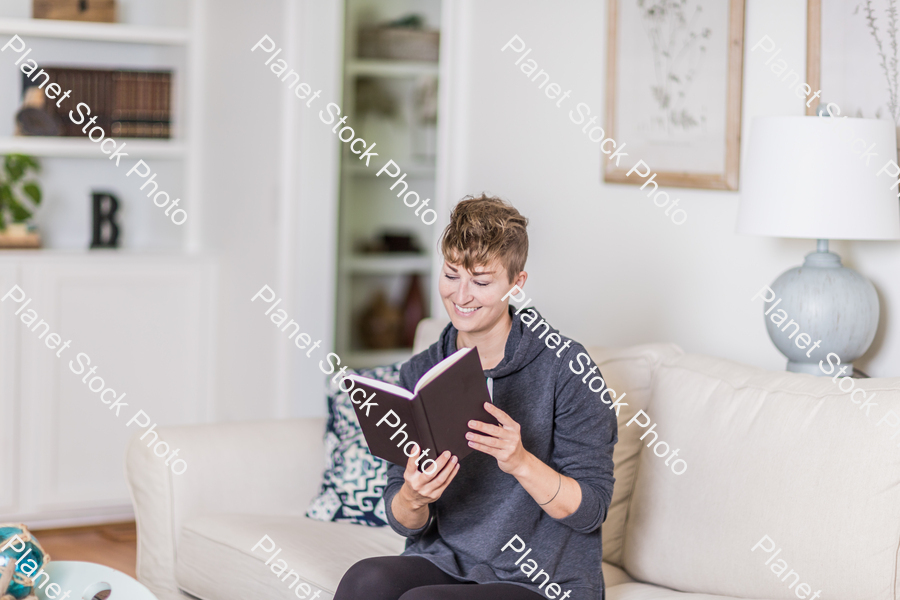 A young lady sitting on the couch stock photo with image ID: 8f96c076-b862-4165-af3c-293cf48ac1a5