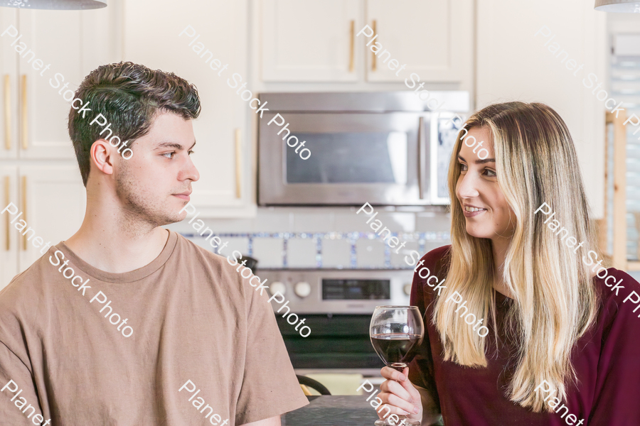 A young couple sitting and enjoying red wine stock photo with image ID: 8feab34a-8554-4e6c-a710-8436a103fef7