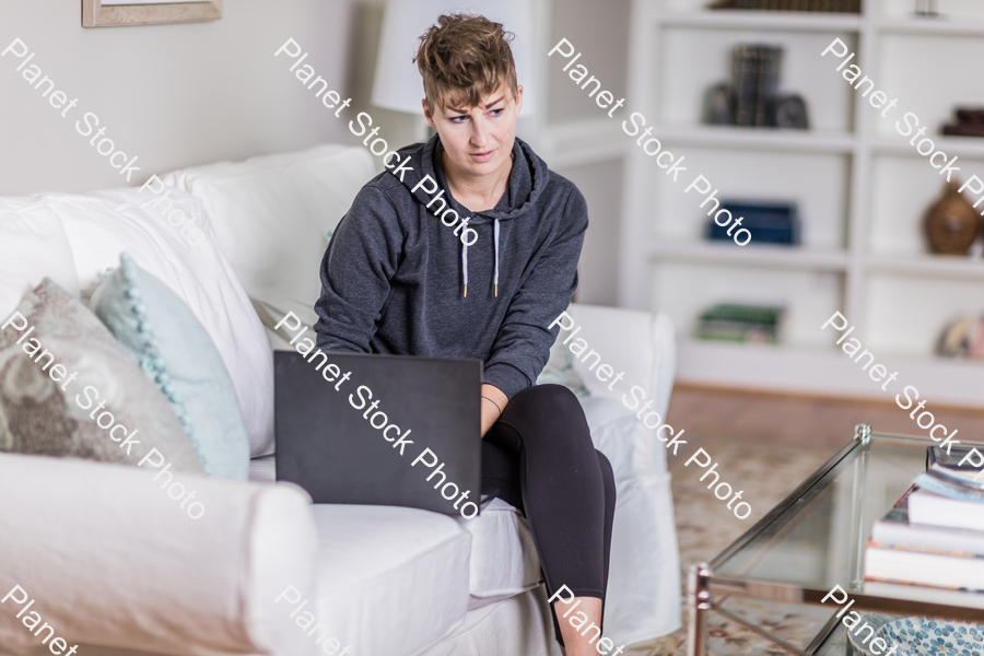 A young lady sitting on the couch stock photo with image ID: 90c36188-62f4-4048-bdb9-735e9bc7fddb