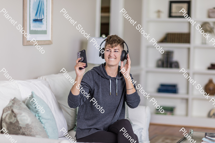 A young lady sitting on the couch stock photo with image ID: 91640447-be5f-4968-9d3e-094d1765e87b