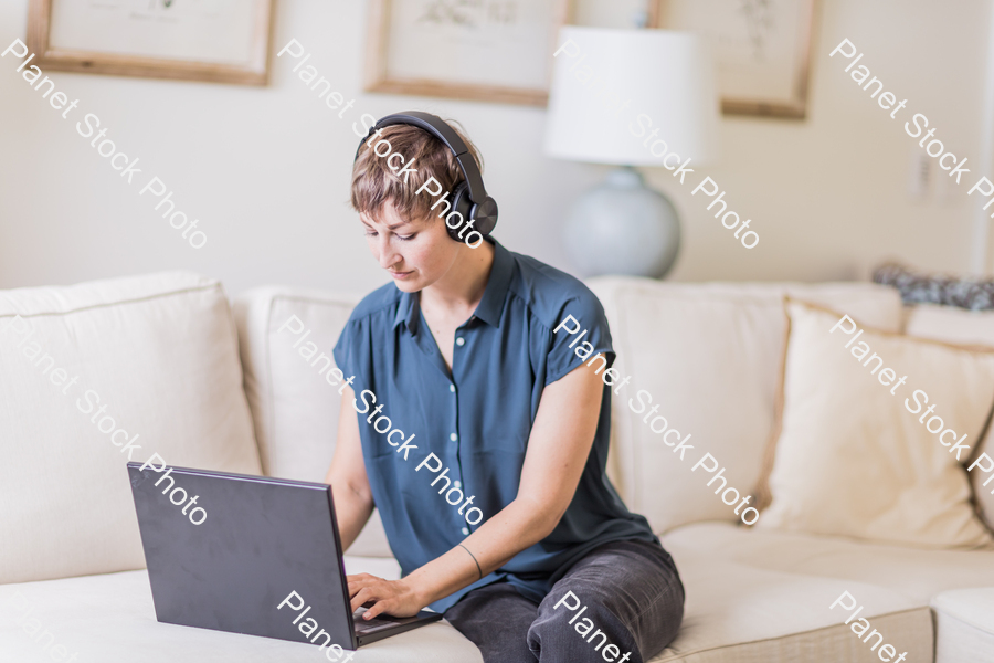 A young lady sitting on the couch stock photo with image ID: 926a581d-c229-4989-aadb-ae177ffbf51a