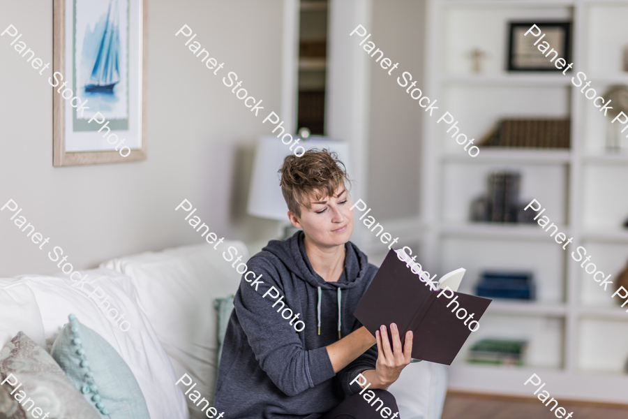 A young lady sitting on the couch stock photo with image ID: 94376ac6-0856-4ede-99e1-b0b690bc373e