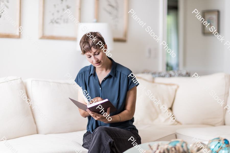A young lady sitting on the couch stock photo with image ID: 94cbefaa-2333-4ce1-a71e-6df39f5710dc