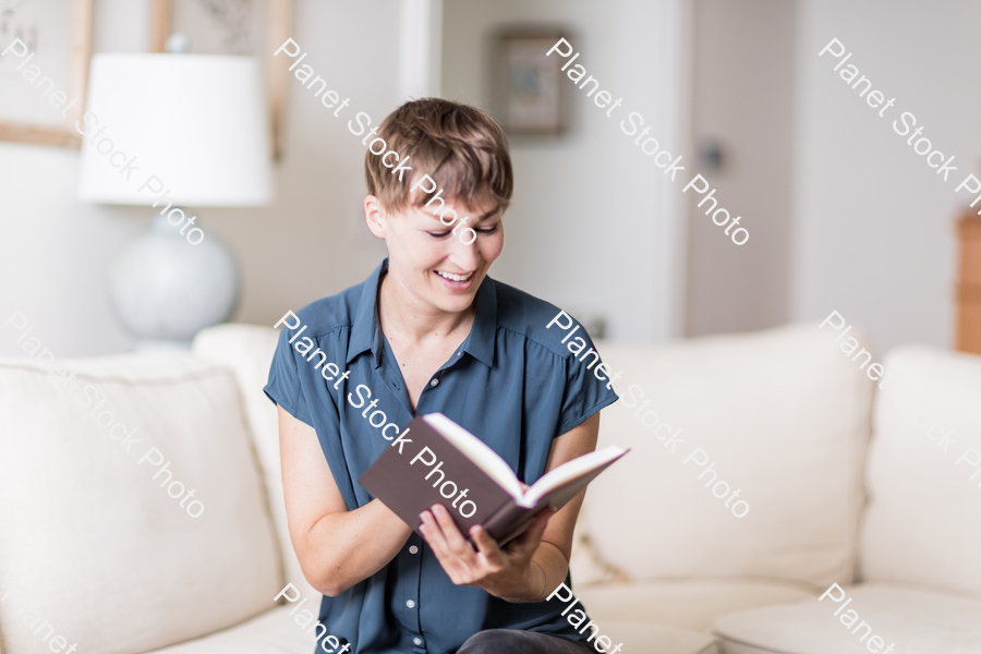 A young lady sitting on the couch stock photo with image ID: 95011b82-475d-434f-992d-22d9b7a5d0bf