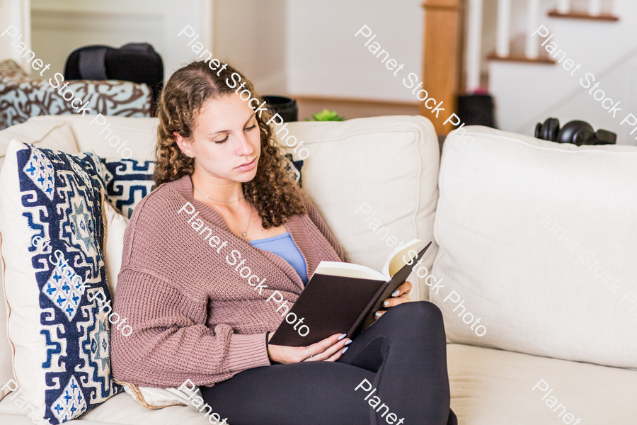 A young lady sitting on the couch stock photo with image ID: 9749f911-8e82-48da-8e10-639dc0f5a854