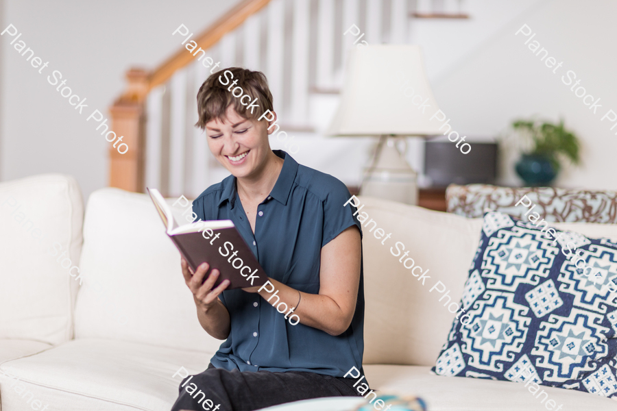 A young lady sitting on the couch stock photo with image ID: 9a03dbbc-0c2d-43be-919e-854ea132ff89