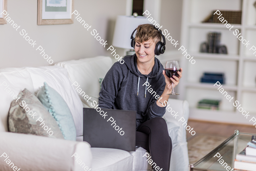 A young lady sitting on the couch stock photo with image ID: 9ba3dac7-ff5c-471d-a79b-acc4d867570f