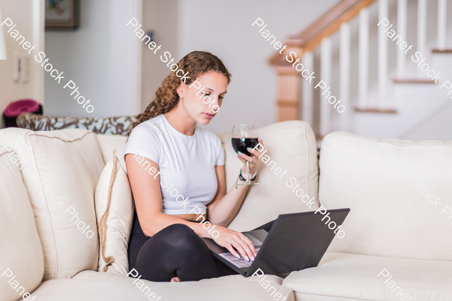 A young lady sitting on the couch stock photo with image ID: 9db74f8e-9796-4f7a-8c3c-037fb08bbeec