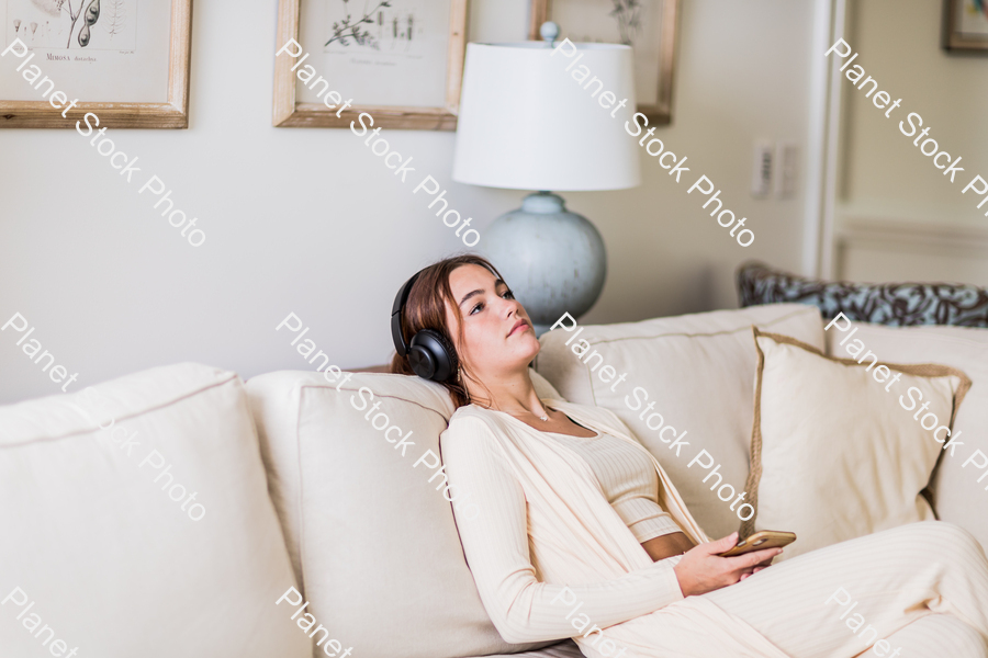 A young lady sitting on the couch stock photo with image ID: 9fc8a955-8b9f-41cb-9be0-59b8edae15dd