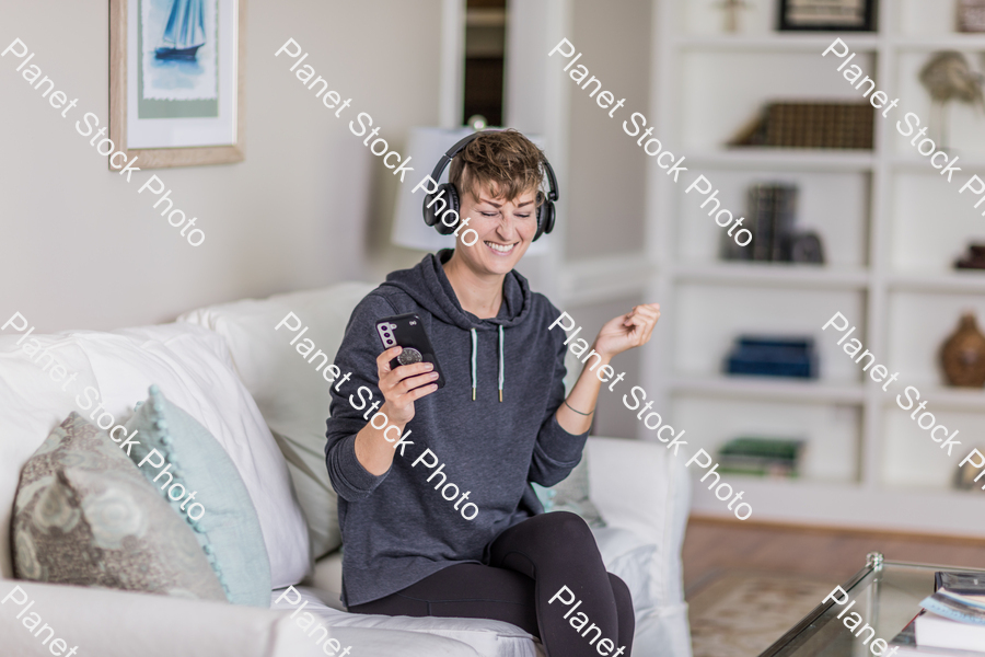 A young lady sitting on the couch stock photo with image ID: a07e6e4e-19c3-4b70-b971-6855847956ad