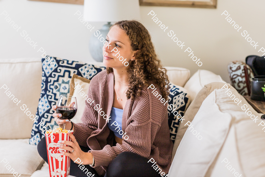 A young lady sitting on the couch stock photo with image ID: a0a3174e-c85c-49b4-9b2f-003d2e8f4877