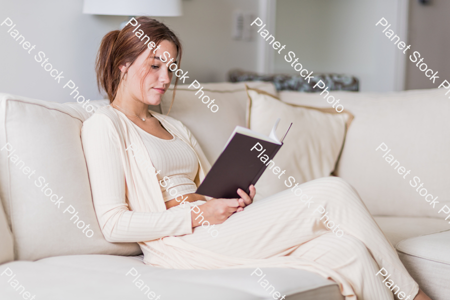 A young lady sitting on the couch stock photo with image ID: a0e9cf7d-d098-4011-a2b7-2a04d2a79ef2