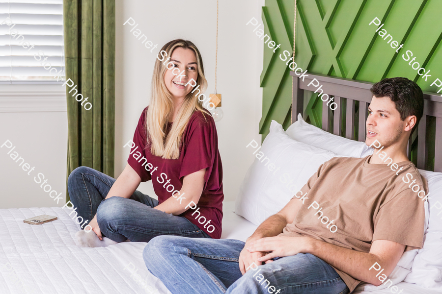 A young couple sitting in bed stock photo with image ID: a32dc131-a8df-4f0e-8557-5bfd6a084377